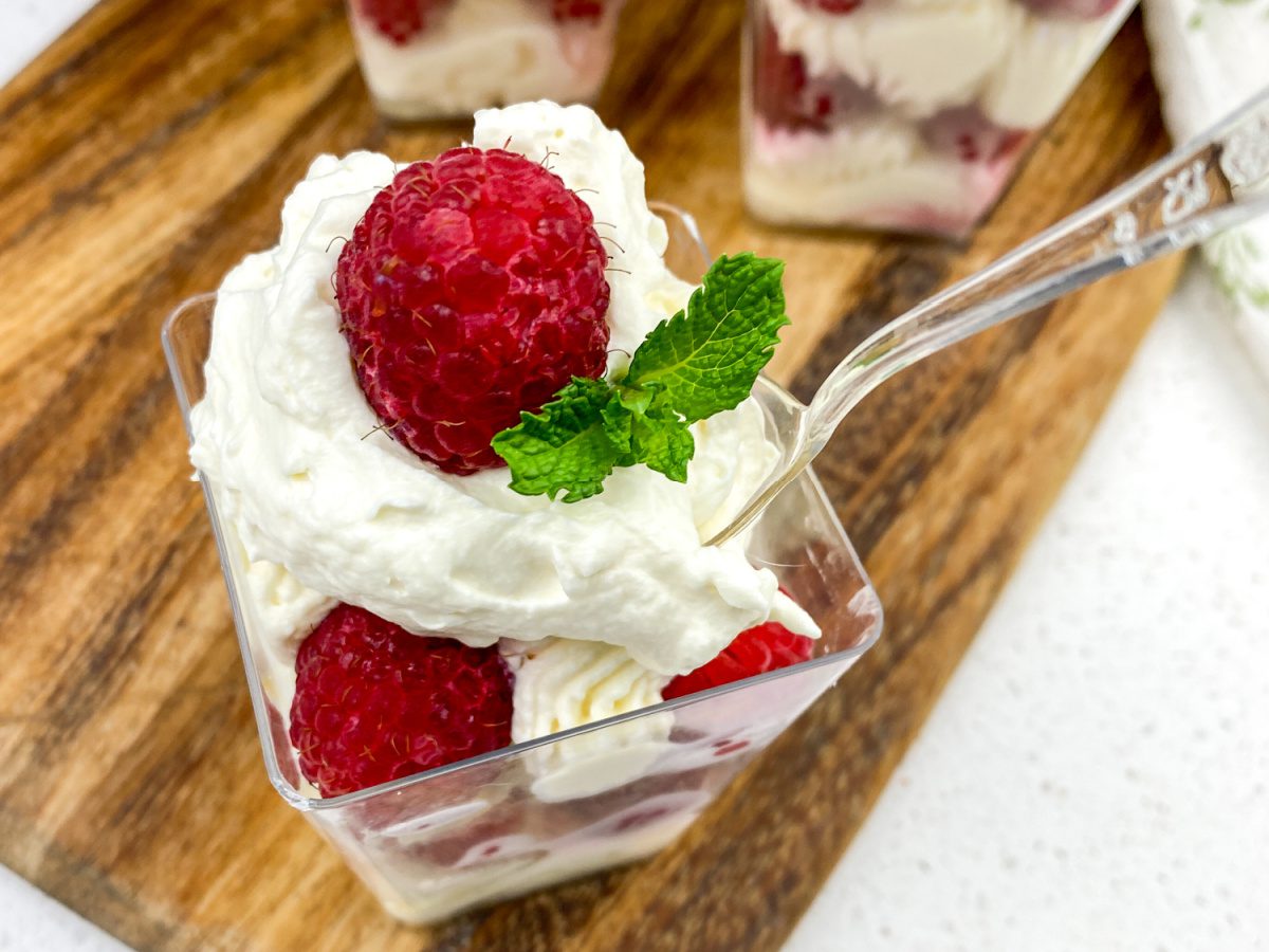 No bake lemon raspberry cheesecake cups in individual dessert cups with whipped cream and mint