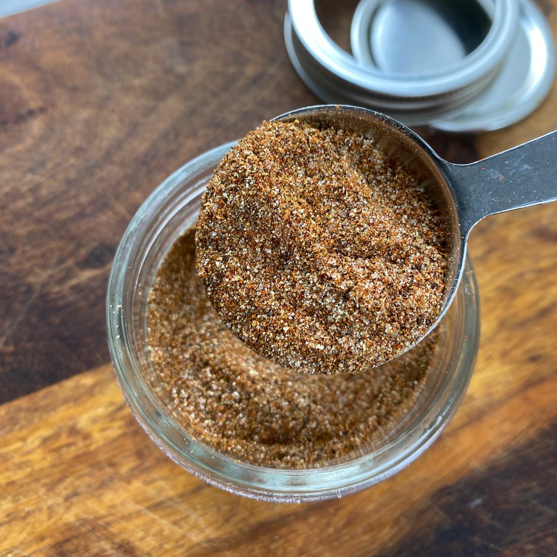 Jar of homemade taco seasoning with a spoon