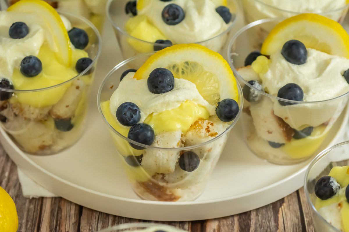 Individual blueberry lemon trifles topped with whipped cream and lemon slices