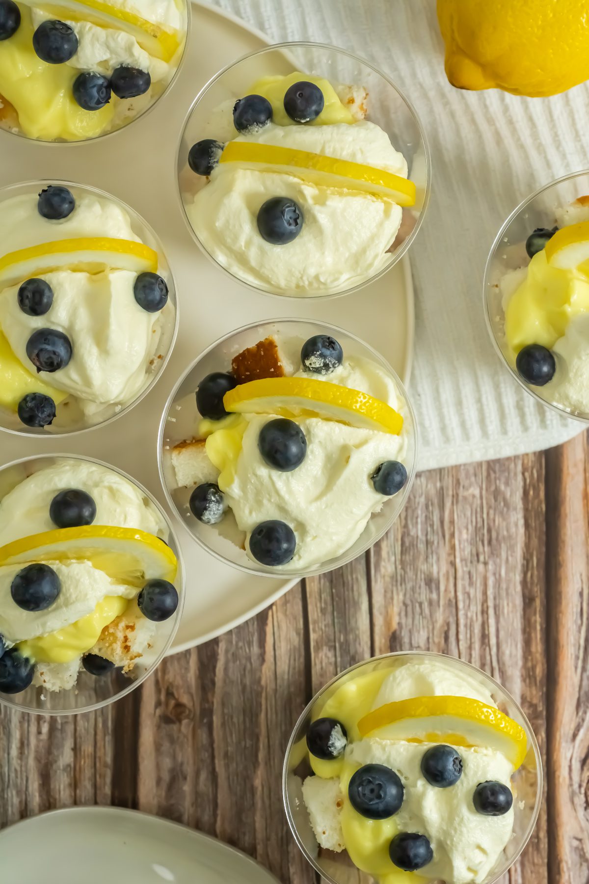 Individual blueberry lemon trifles topped with whipped cream and lemon slices