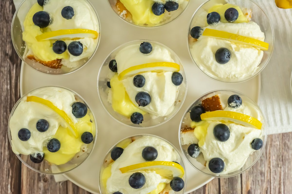 Individual blueberry lemon trifles topped with whipped cream and lemon slices