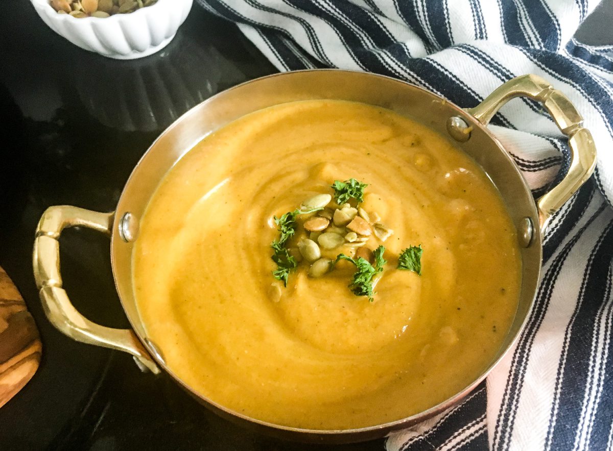 Curried butternut squash soup in bowl topped with pumpkin seeds