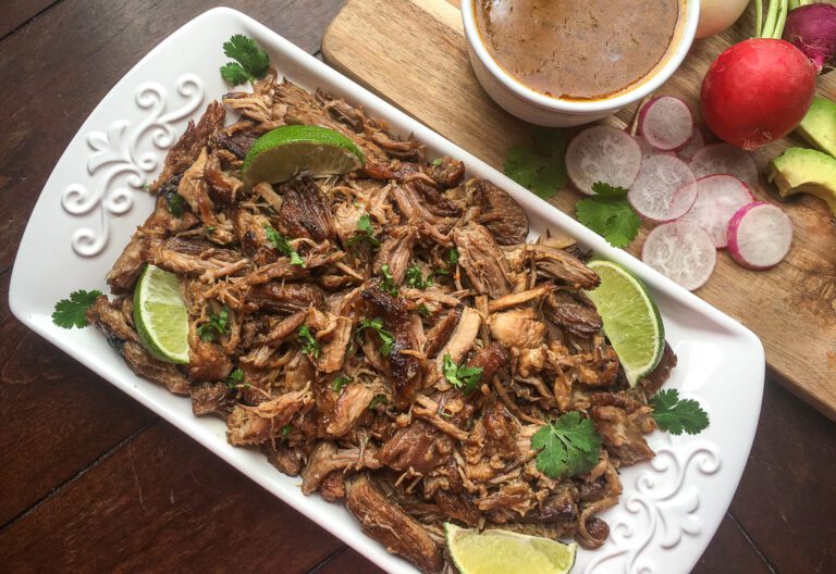 Instant Pot Pork Carnitas with crispy edges, lime wedges, and cilantro